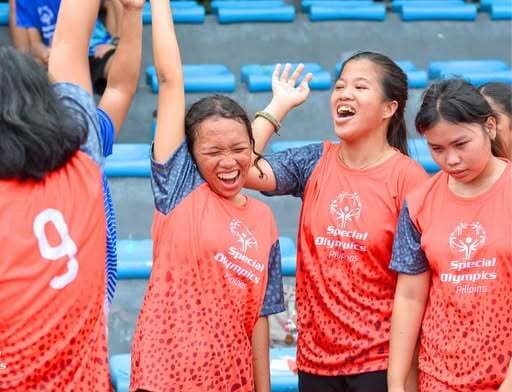 Lire celebrates with her Special Olympics Philippines teammates.
